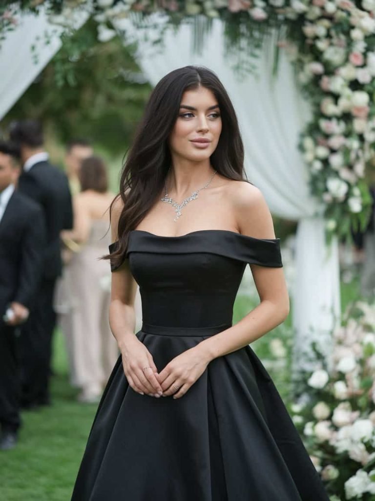 Gorgeous off-the-shoulder black gown embodies the romantic vibe of Black Tie Wedding Guest Dresses.
