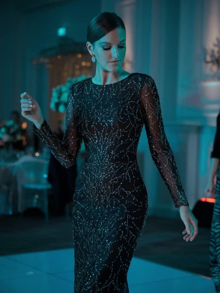 Modern Black Tie Wedding Guest Dress in a fitted black sequin sheath, perfect for dancing under the lights.
