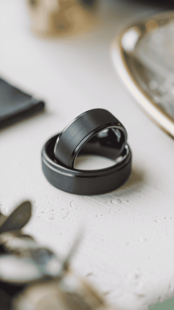 Close-up of a matte finish black wedding band elegantly placed on a soft ring pillow.
