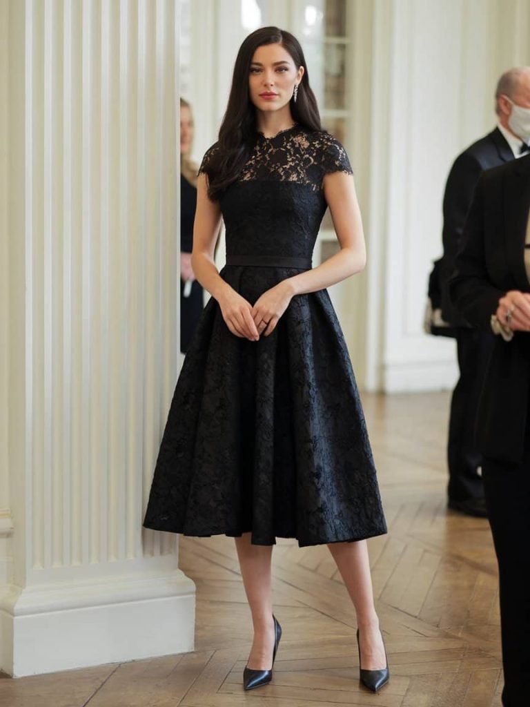 Timeless black cap-sleeve lace gown captures the charm of Black Tie Wedding Guest Dresses.
