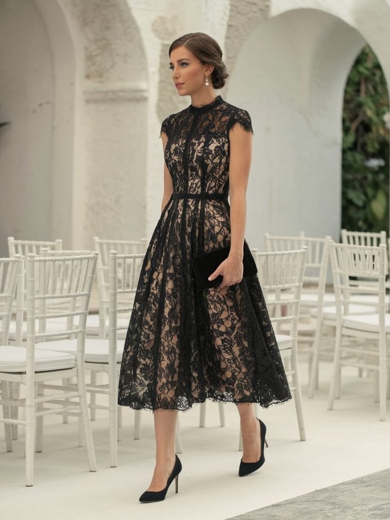 Black lace dress with cap sleeves epitomizes Black Tie Wedding Guest Dresses at stylish wedding events.
