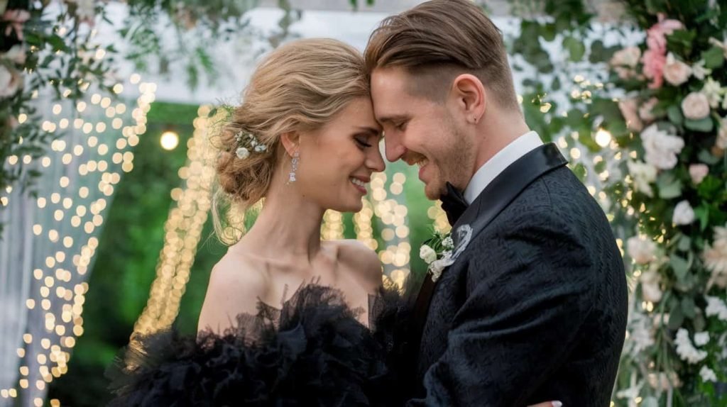 Romantic close-up from the Avakov Wedding New Jersey, showcasing the bride and groom in a moment of pure joy. Their intimate embrace is framed by twinkling fairy lights and vibrant greenery, highlighting the elegance and charm of this New Jersey wedding.