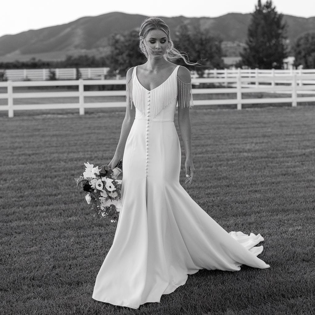 Elegant Ranch Chic Western wedding dress with fringe and fitted waist, ideal for a chic and understated outdoor wedding.