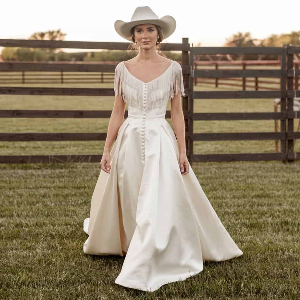 Modern Ranch Chic Western wedding dress with flowing skirt and fringe accents, perfect for a comfortable yet stylish outdoor wedding.