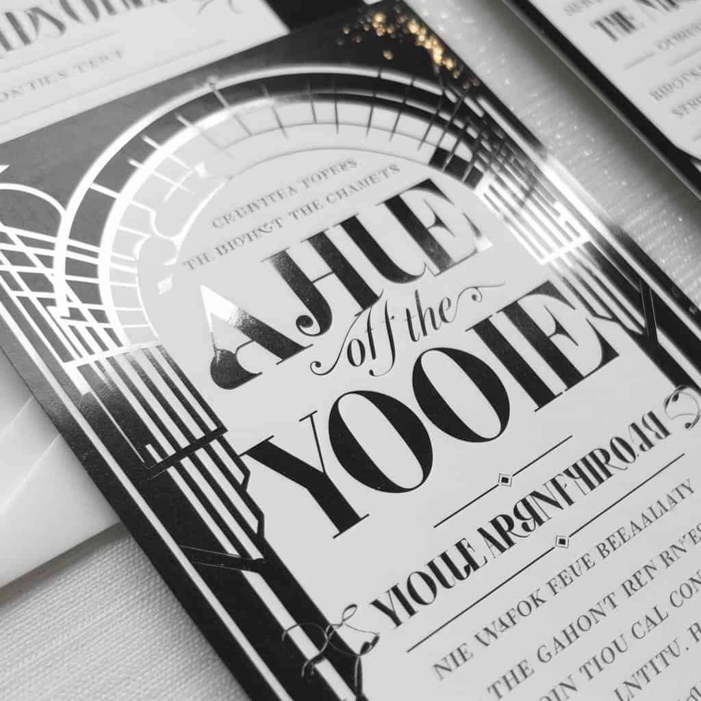 Glamorous black and white wedding invitation featuring luxurious typography and art deco embellishments.