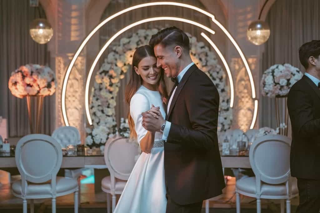 The image features a close-up of a newly married couple dancing, radiating joy and intimacy, with the bride and groom lost in the moment.
