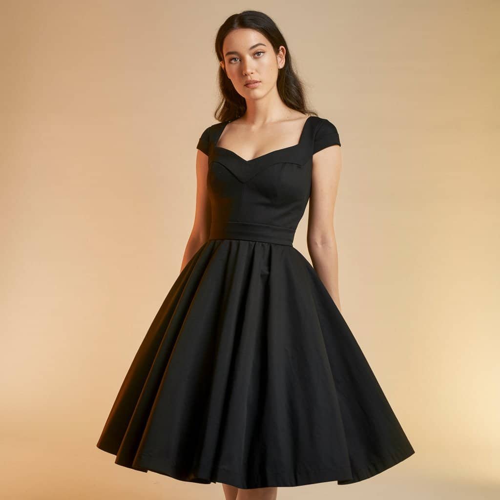 Black Wedding Guest Dresses: Vintage Tea-Length Dress with Lace Accents – A classic black tea-length wedding guest dress featuring delicate lace accents for an added vintage flair.