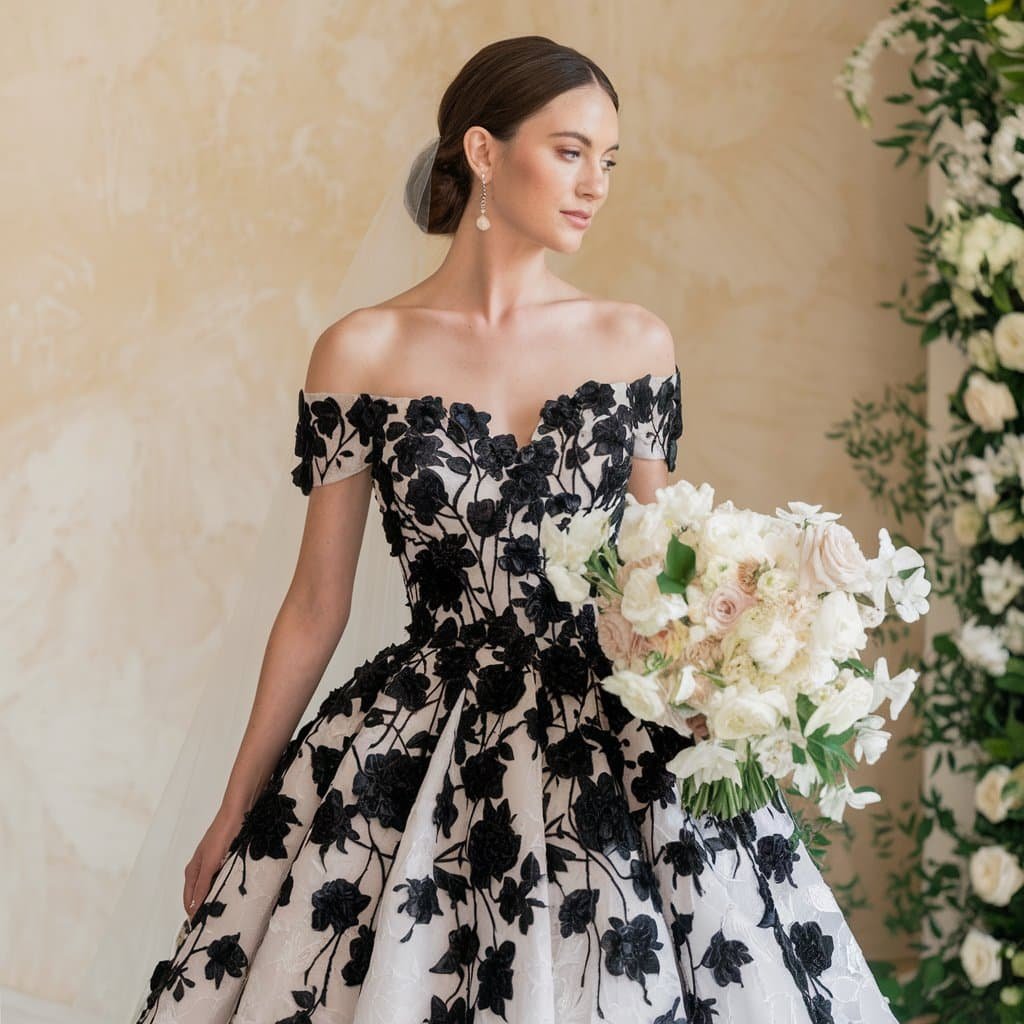 Bride in a stunning black and white wedding gown featuring delicate floral appliqué for an elegant, textured look.