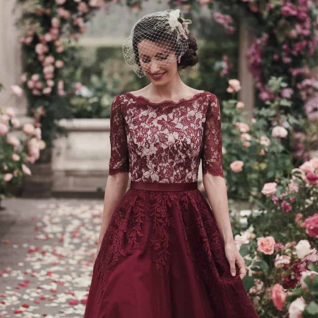 Bride in a burgundy A-line red wedding dress with intricate lace, perfect for vintage-inspired ceremonies.