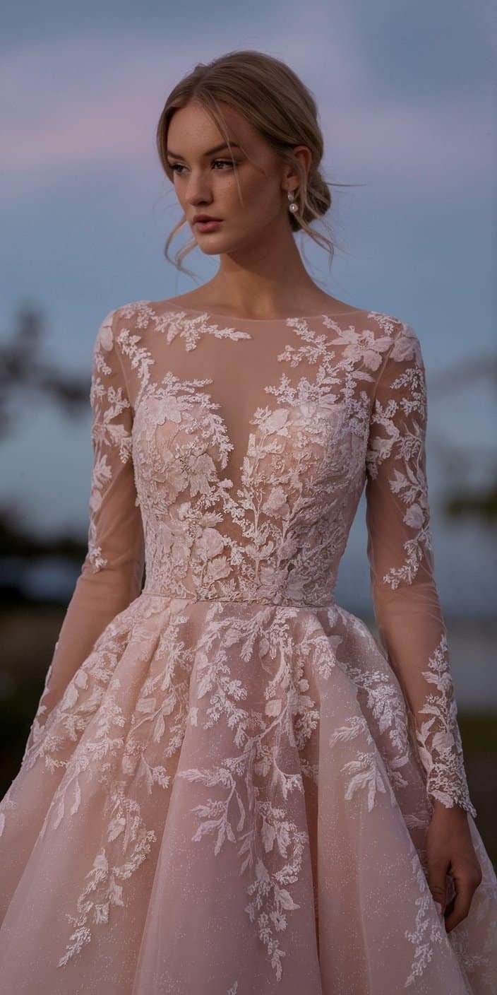 Bride in a classic blush wedding dress adorned with lace designs, surrounded by a soft twilight setting.