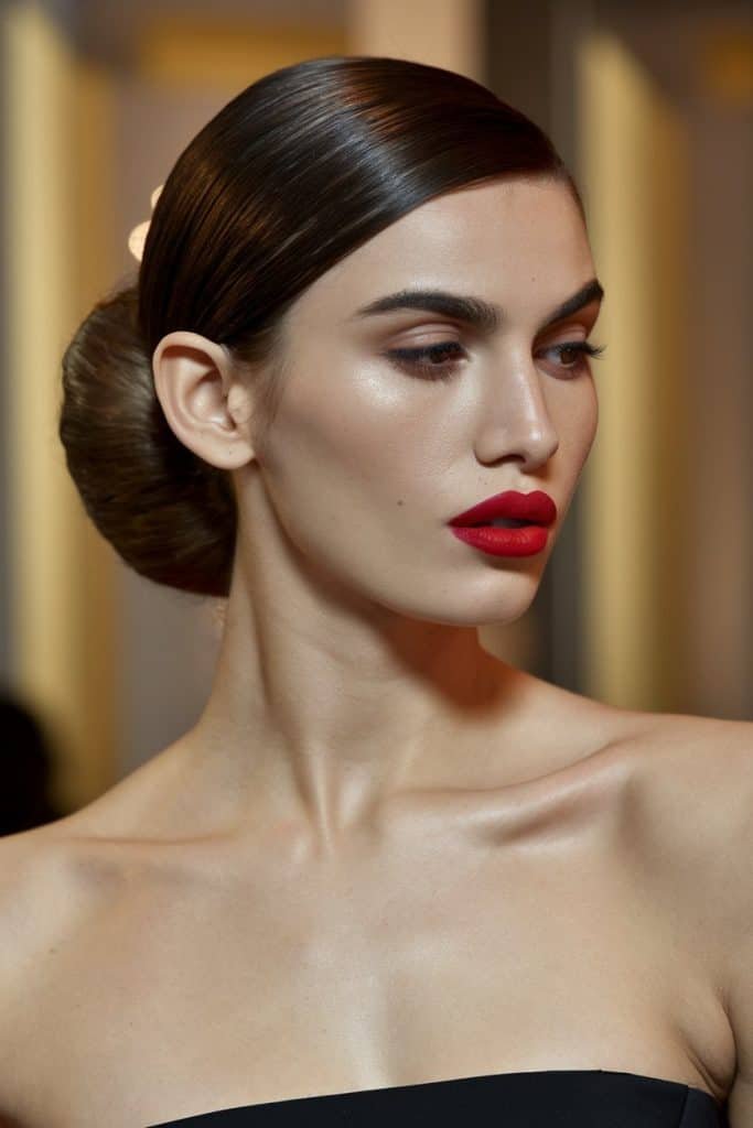 Valentine's Day dress styled with a sleek bun and daring red lipstick for a confident, chic appearance
