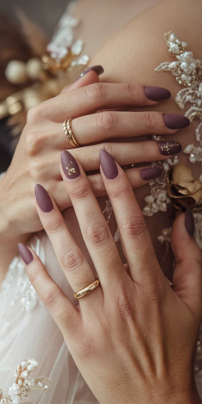 Stylish dusty mauve wedding nails featuring delicate gold flecks, adding a touch of glamour to matte finishes.