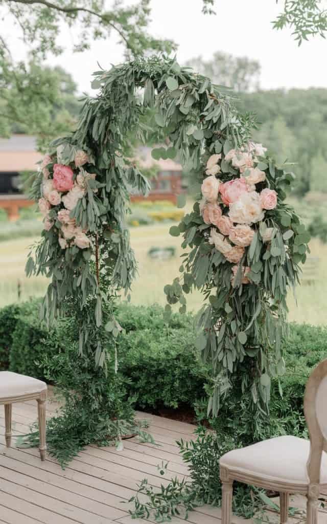 Wedding Arch Flowers featuring a beautiful blend of fragrant eucalyptus leaves and delicate peonies and garden roses, creating a whimsical and natural atmosphere.