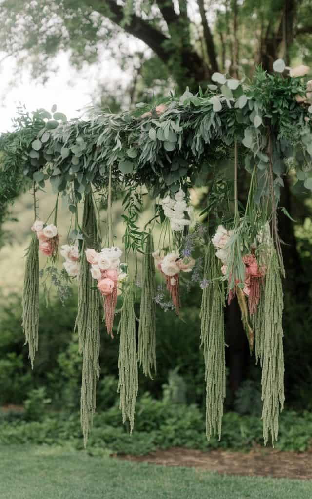 Innovative Wedding Arch Flowers with hanging floral installations suspended from above, creating an upside-down floral spectacle for an unforgettable ceremony.
