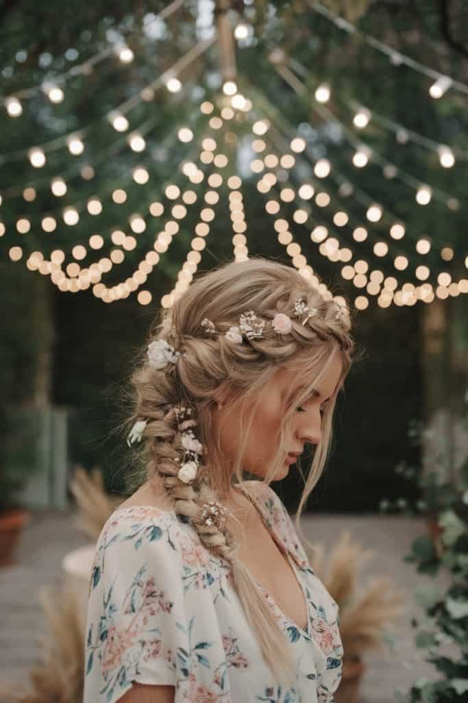 Loose braid with enchanting flower details complements a floral Valentine's Day dress for a magical evening