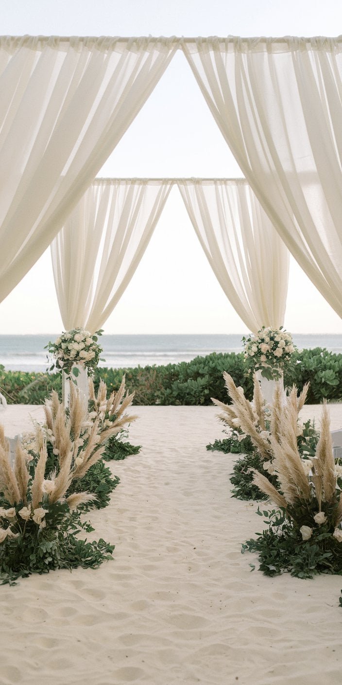 Outdoor ceremony setup featuring ivory backdrops, sand-colored details, and dusty olive bouquets, showcasing ivory, sand, and dusty olive earth tone wedding color ideas.
